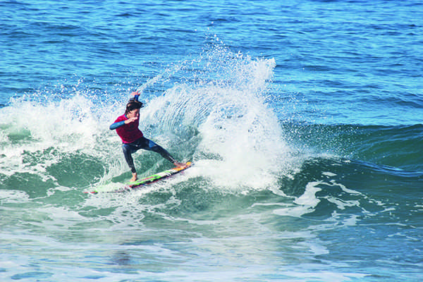 A surf club member catches a wave.
