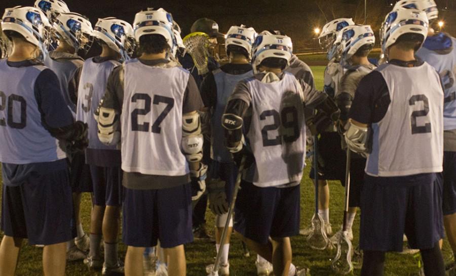 Lacrosse+team+wraps+up+nightly+practice+with+a+huddle.
