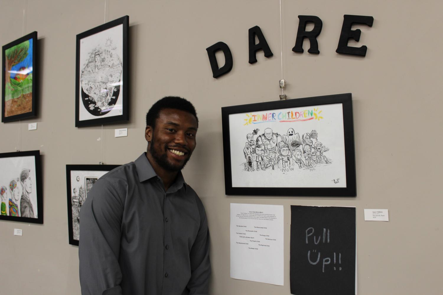 Artist Dare Talley standing next to his artwork during his “Inner Child” exhibition at Charity Wings on Sept. 1.