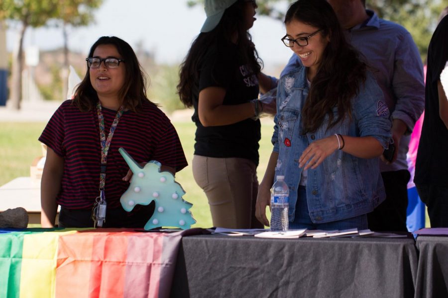 During u-hour on October 12, student representatives, Gabrielle Gilbert and Dinora Rodriguez, happily stand ready to share information about the Pride Center and the events they hold.