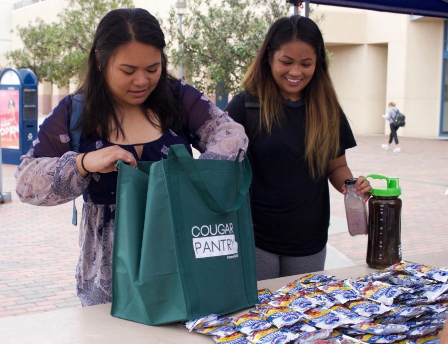 Cheryl Corpuz and Creska Radoc collect food for the  Cougar Pantry held on September 21.