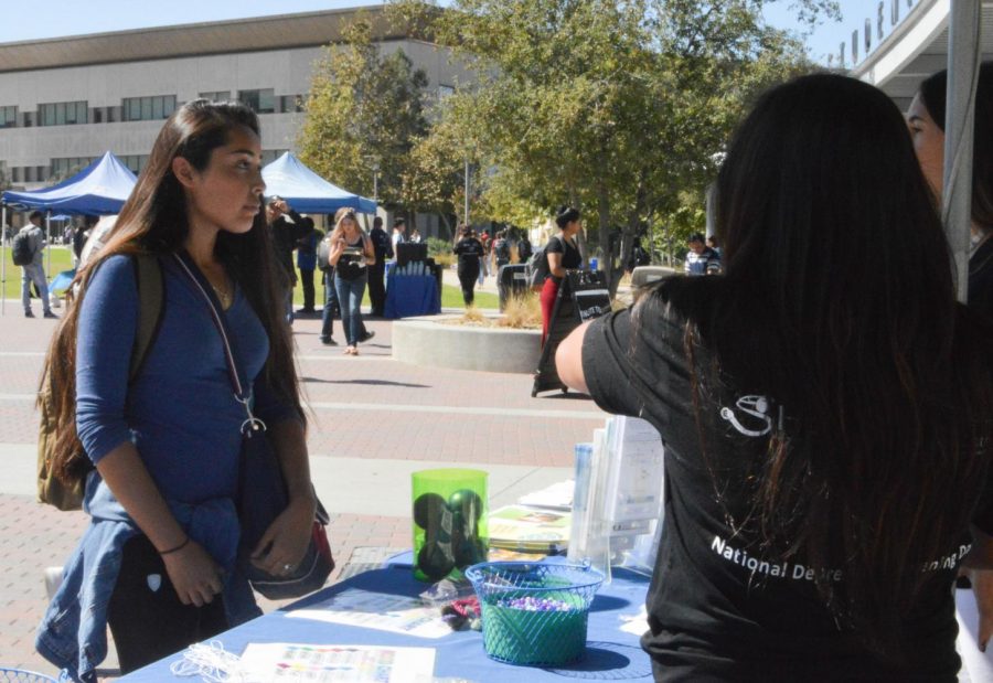 During U-hour on National Depression Screening Day, CSUSM student, Jessica Cortez, listens to student volunteers explain tips for managing stress and the importance of understanding our ever-changing moods.