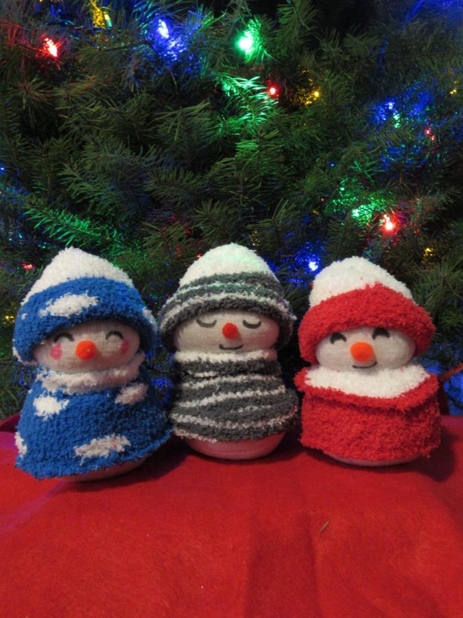 Inexpensive sock snowman under the christmas tree adds a perfect christmas magic.