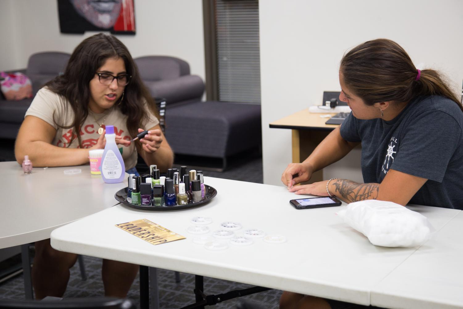Alexis VanPelt and Natalie De La Rosa get to know each other as they paint their nails in the Gender Equity Center on August 30.
