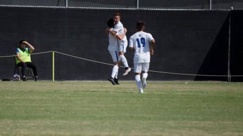 Midfielder Kevin Reyes runs to join his teammates in celebration.