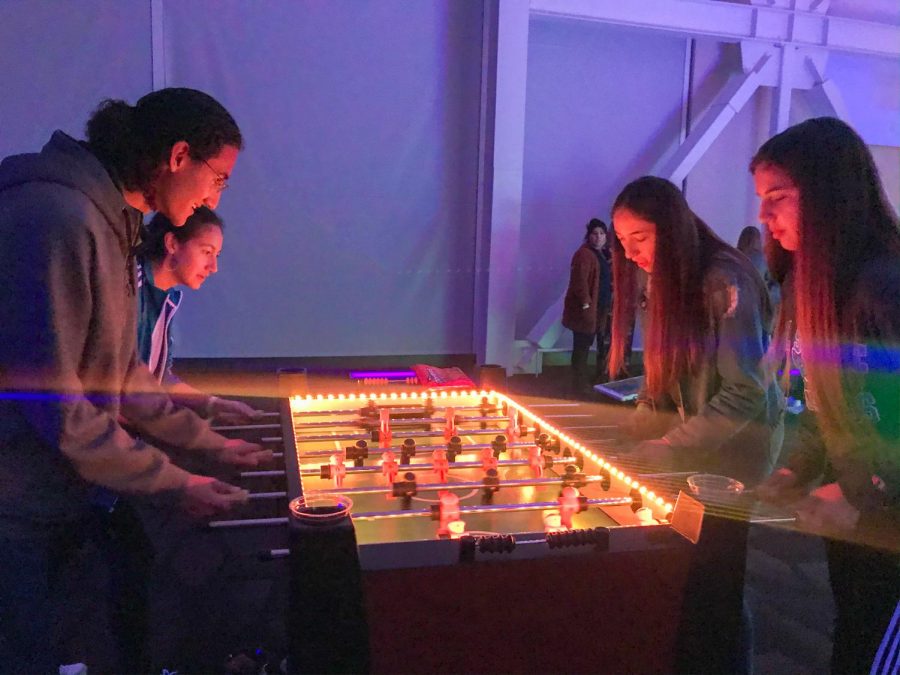 Students go head to head in a game of foosball.