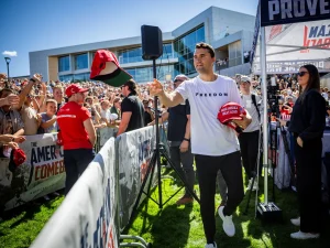 Charlie Kirk on the day of his assassination, handing out MAGA hats.